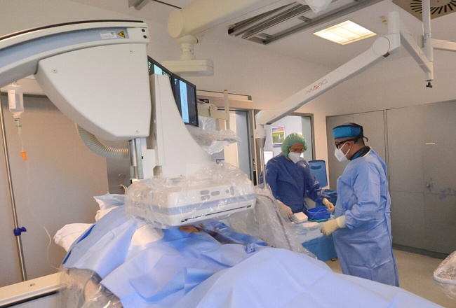 DSA-Anlage (Digitale Subtraktions Angiographie): Patient wird untersucht von dem Arzt und seiner Assistentin